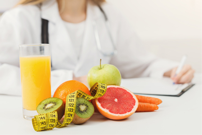 רופאה כותבת מרשם לתרופות ולצידה סרט מדידה, פירות וירקות - כל אלה משמשים למניעת מחלות לב